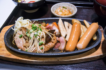 fire pork with mushroom and sausage on hot pan.