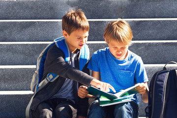 Two boys doing homework outdoors. Back to school concept.