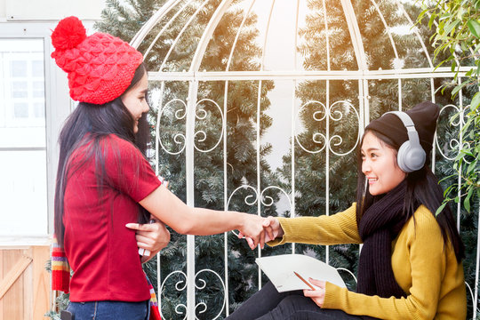 Woman student shaking hands with her friend - friendship and togetherness concept