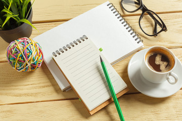 top view. coffee cup with coffee. pen putting on blank notebook.