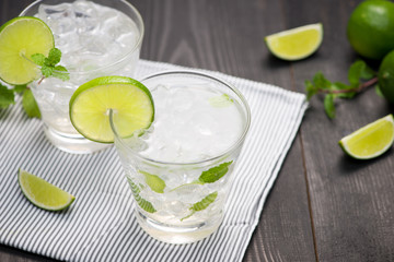 Fresh cocktail with lime, ice and mint on a rustic background. Copy space, top view