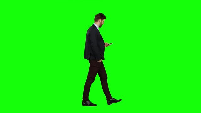 Guy walks down the street, puts his hand in his pocket and waves. Green screen