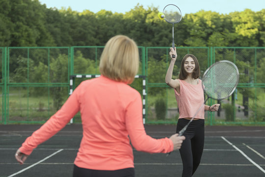 Mother and daughter playing badminton in court