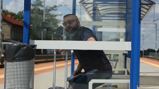 Man finish using laptop on the platform and leaving the stop
