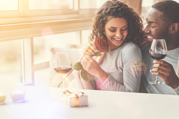 Cheerful delighted woman holding a flower