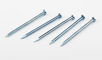 Various nails in line on white background. Copy space. Isolated.
