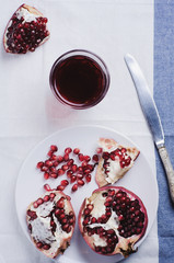 Red pomegranate and juice in a class on a light table