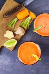 Carrot ginger smoothie, garnished with lime. View from above, top studio shot