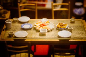 close up Miniature clay figurine Thailand's floating market,Miniature boat carrying tropical fruit on wood background