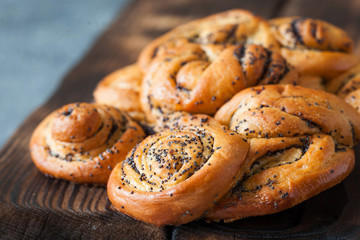 Rolled braided pie with poppy seeds on rustic board close up