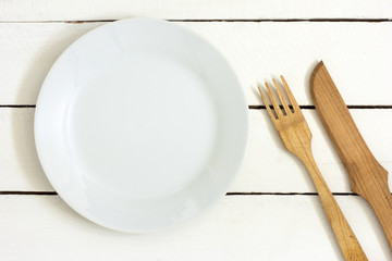 Wooden cutlery on the Table./Wooden cutlery and empty plate on the Table 