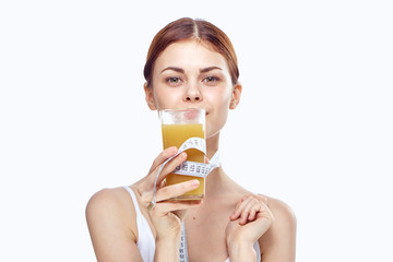 Young beautiful woman on white isolated background holds a glass of juice, diet, health