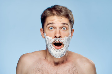 Man with a beard on a gray background in shaving foam