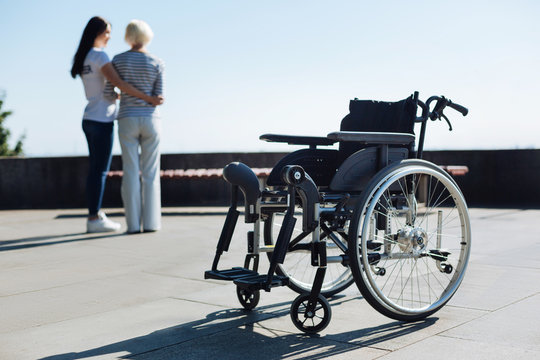 Vibrant Motivated Volunteer Assisting Senior Lady Taking A Stroll