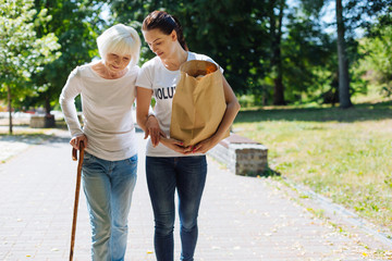 Incredible woman assisting elderly lady with her everyday routine