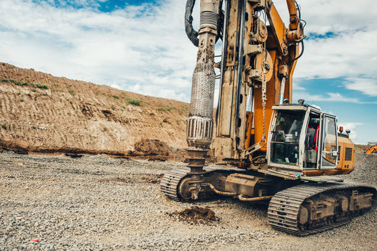 Construction Site, Highway Building With Industrial Rotary Drilling Machinery Making Holes In The Ground