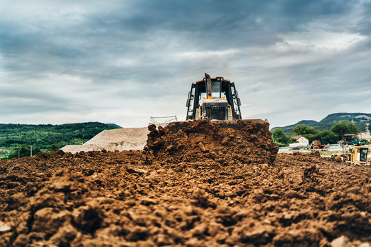 Mini Bulldozer Moving Dirt And Earth With Scoop. Industrial Details Of Landscaping