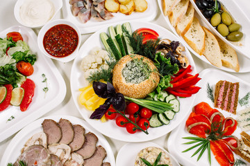 White tablecloth, surrounded by snacks. Variety of dishes. Kitchen, menu, concept of food