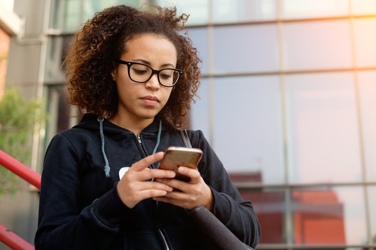 Young Millenial Girl Texting On Her Phone