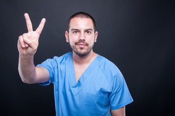 Portrait of male medical nurse showing peace gesture