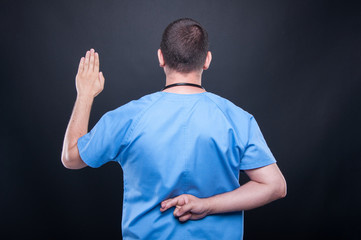 Back look of male doctor with stethoscope taking fake oath