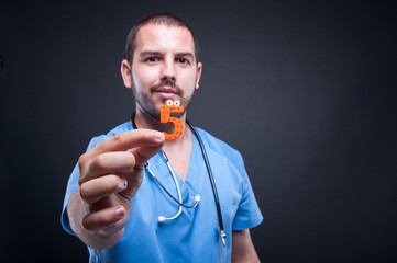 Selective focus of male pediatrician showing number five