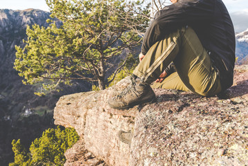 hiker standing on the rocks and contemplates a beautiful mountain landscape -wanderlust travel concept with sporty people at excursion in wild nature - outdoor activity italian Alps Italy