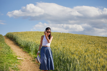 Woman is walking along the road among the fields and a typical Tuscan landscape behind her. Tuscany, Italy