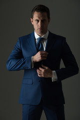businessman with serious face holding collar in suit
