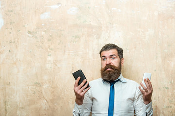 hipster or bearded man compare mobile phone and smartphone