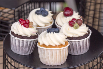 Delicious cupcakes with fruit on the counter