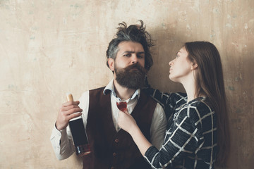 Woman with glass looking at man with bottle of wine