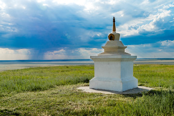 Buddhist stupa on the background of the steppe and blue sky