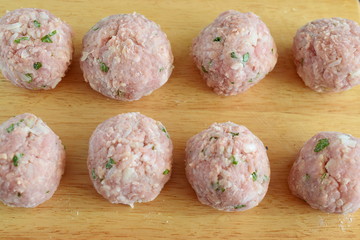 Raw beef meatballs with mint and rice on a wooden cutting board. Step by step cooking. Traditional greek food