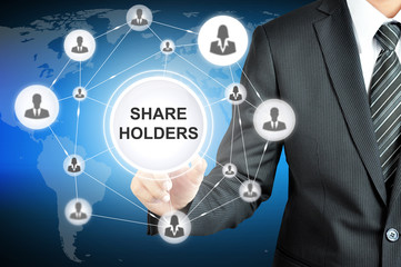 Businessman pointing on SHAREHOLDERS sign on virtual screen with people icons linked as network