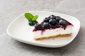 Piece of blueberry cheesecake on gray stone
