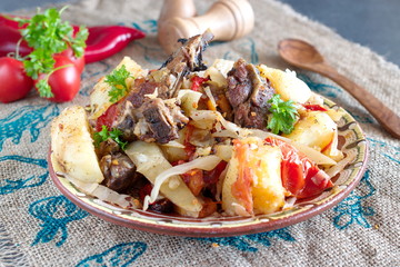 Traditional stew with lamb chops and vegetables: onion, cabbage, potato, tomato, paprika in a bowl on a cloth background. Healthy eating concept