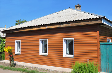 Old house with asbestos roof repair and renovation with plastic siding wall. Siding house. Remodel old house.