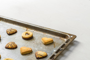 Gebäck Kekse mit Schokolade in Form als Herz liegen dekorativ nach dem Backen auf Backblech