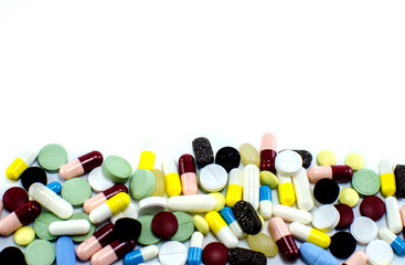 A lot of pills of different colors on a white background.