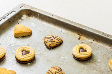 Gebäck Kekse mit Schokolade in Herzform liegen dekorativ nach dem Backen auf Backblech