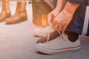 Naklejka premium Hands are laced sneakers.