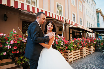 Amazing young attractive newly married couple walking and posing in the downtown with beautiful...