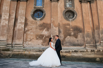 Amazing young attractive newly married couple walking and posing in the downtown with beautiful and...