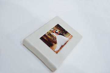 Sohisticated white leather wedding photobook or photo album on the white background.