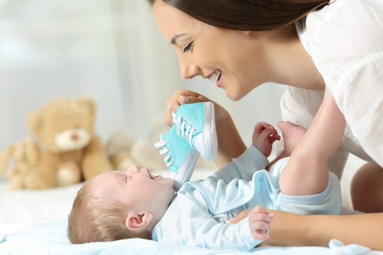 Mother Showing New Shoes To Her Baby