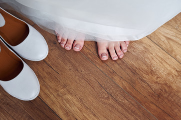 White bride shoes and bride barefoot