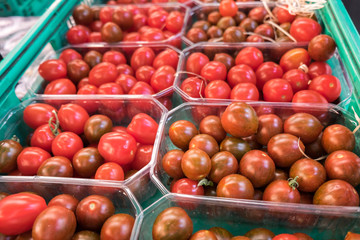 Organics cherry tomatoes in plastic boxes sold at  local city market. Provence. France