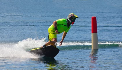 Poster Männlicher Motosurf-Konkurrent, der eine Ecke mit Geschwindigkeit nimmt und viel Spray erzeugt. © harlequin9