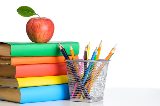 School accessories, books and fresh apple against white background